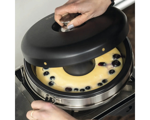 Frau öffnet Backofen mit Blaubeerkuchen