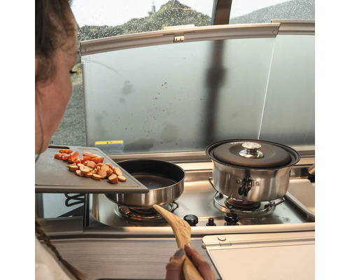 Kochen im Wohnmobil mit Zutaten auf einem Schneidebrett neben dem Herd