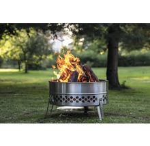 Feuerstelle aus Metall mit brennendem Holz im Garten.
