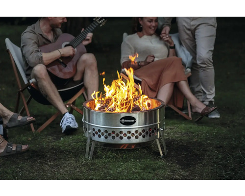 Feuerstelle aus Stahl mit brennendem Holz und Personen im Hintergrund