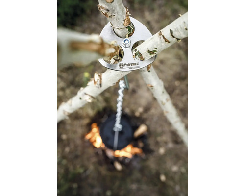 Petromax Logo über einem Dreibein mit Kette über einem Lagerfeuer.