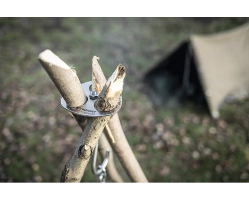 Petromax Logo, Dreibeinadapter mit Holzstücken und Zelt im Hintergrund