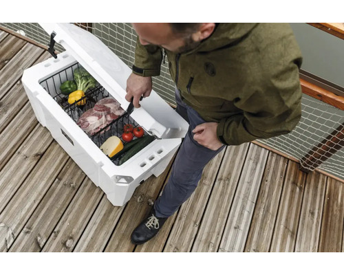 Geöffnete Kühlbox mit Lebensmitteln und Person auf Holzterrasse