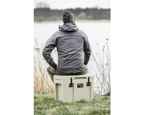 Person sitzt auf einer Petromax Kühlbox kx25 in der Natur