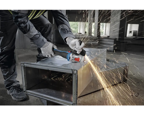 Handwerker bearbeitet Metall mit einem Winkelschleifer, Funken fliegen.