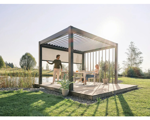 Freistehende Terrassenüberdachung mit Lamellendach, Seitenmarkise und zwei Personen im Garten.