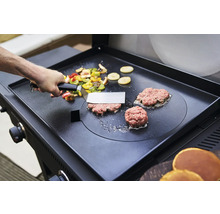 Gemüse und Burger werden auf einer Grillplatte zubereitet.