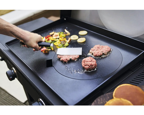 Gemüse und Burger werden auf einer Grillplatte zubereitet.