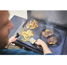 Mann bereitet Steak, Gemüse und Reis auf einem Grill zu