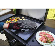 Eine Person bereitet Gemüse und Fleisch auf einem Grill zu.