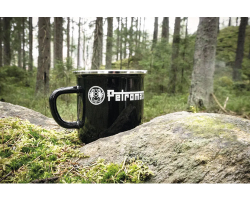 Schwarze Petromax Emaille Tasse auf einem Stein im Wald