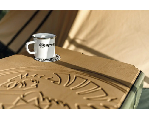Emailletasse mit Petromax Logo auf Untersetzer auf Tisch