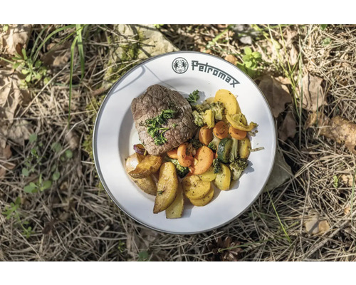 Teller mit Steak, Kartoffeln und Gemüse auf dem Boden