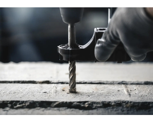 Bohrmaschine mit Betonbohrer bohrt Loch in Beton