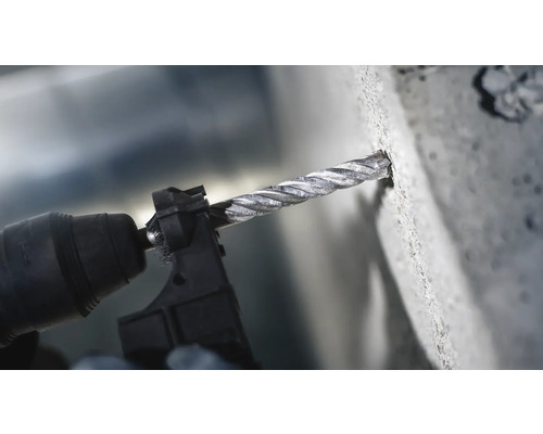 Bohrmaschine mit Betonbohrer beim Bohren in Beton