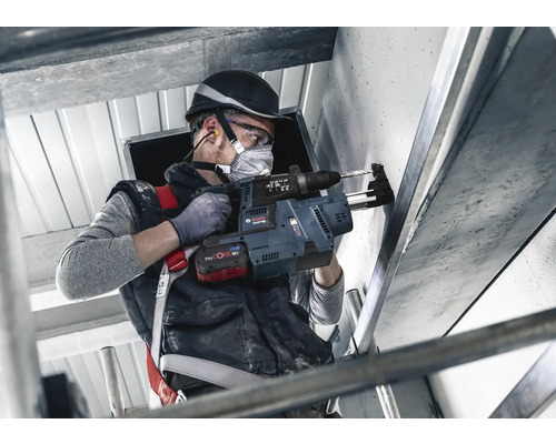 Handwerker bohrt mit einer Bosch Akku-Bohrmaschine ein Loch in eine Wand.