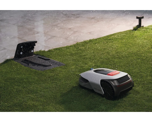 Rasenmähroboter mit Ladestation auf Rasenfläche