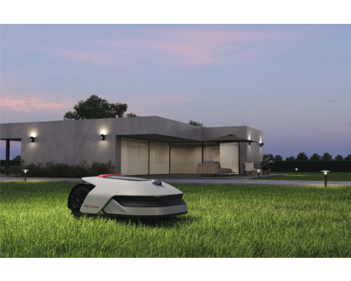 Rasenmähroboter auf einer Rasenfläche vor einem Haus