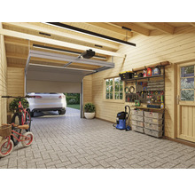 Innenansicht einer Garage mit Werkzeugwand, Regalen, Staubsauger, Fahrrädern und einem Auto