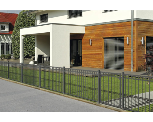 Haus mit Metallzaun zur Grundstücksbegrenzung