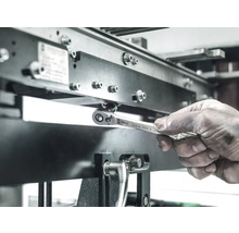 Ein Arbeiter benutzt einen Wera Zyklop 8004 A Ringschlüssel, um eine Schraube an einer Metallstruktur festzuziehen.