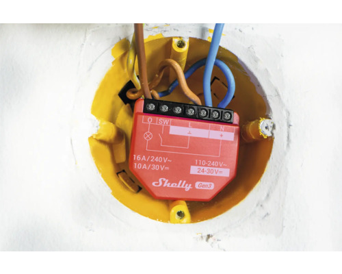 Detailaufnahme eines Shelly Gen3 Relais in einer gelben Unterputzdose mit elektrischen Leitungen.