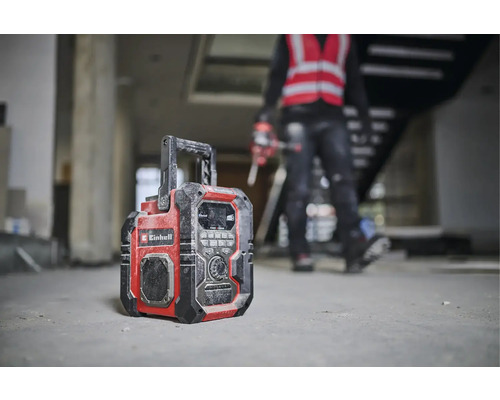 Ein Baustellenradio der Marke Einhell steht auf dem Boden eines Rohbaus.