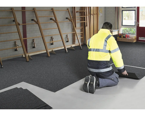 Verlegung von Bodenfliesen in einer Turnhalle mit Sprossenwand