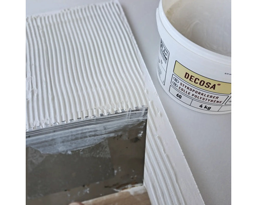 Decosa Styroporkleber im Eimer neben einer bestrichenen Fläche