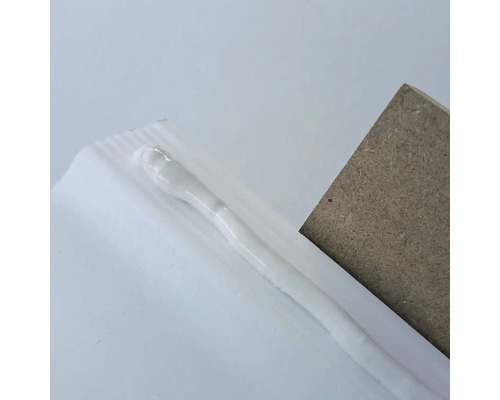 Dichtstoff zwischen einem Stück Holz und einer Oberfläche