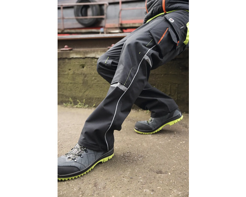 Person in Arbeitskleidung mit Arbeitshose und Sicherheitsschuhen