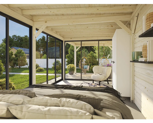 Helles Zimmer mit Holzbalkendecke, Bett und Blick durch Fenster auf Garten