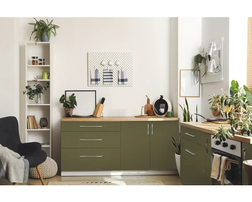 Helle Küche mit grünen Schränken, Holzarbeitsplatten und diversen Dekorationsgegenständen