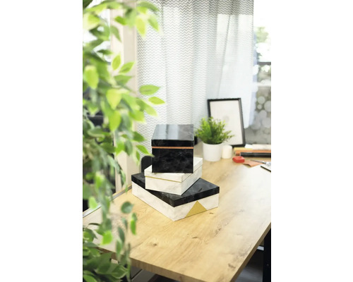 Stapel von drei dekorativen Schachteln auf einem Tisch