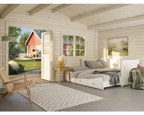 Innenansicht eines Holzhauses mit Bett, Teppich und geöffneter Tür zum Garten