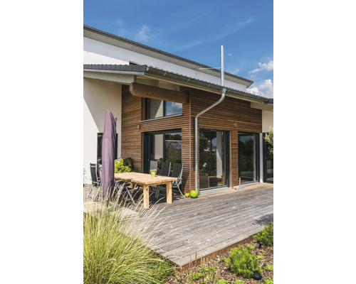 Modernes Haus mit Holzverkleidung, Terrasse und Gartenmöbeln.
