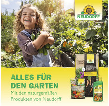 Eine lächelnde junge Gärtnerin hält Gurken im Garten, umgeben von Neudorff Gartenprodukten.