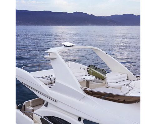 Heckansicht eines weißen Motorbootes auf dem Wasser mit Bergen im Hintergrund