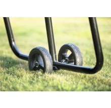 Detailaufnahme von zwei Rädern eines Transportwagens auf Gras.
