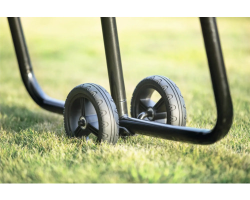 Detailaufnahme von zwei Rädern eines Transportwagens auf Gras.