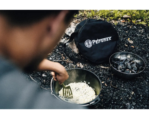 Zubereitung von Speisen im Dutch Oven mit Petromax Tasche und Schüssel mit Muscheln im Freien