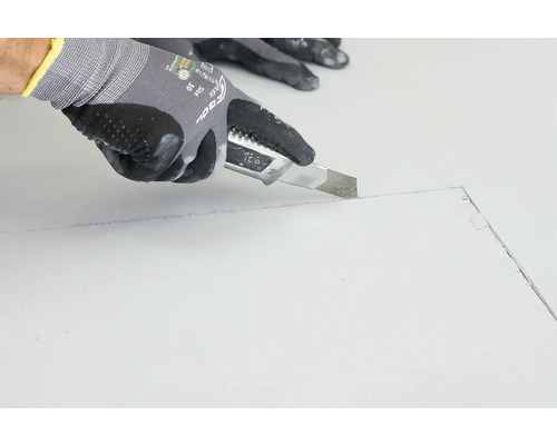 Hand schneidet Material mit einem Universalmesser