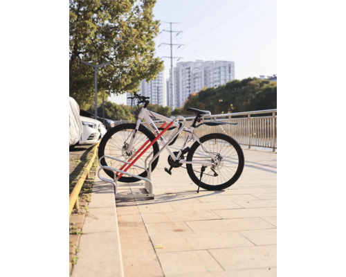 Fahrrad geparkt in einem Fahrradständer vor einer städtischen Kulisse
