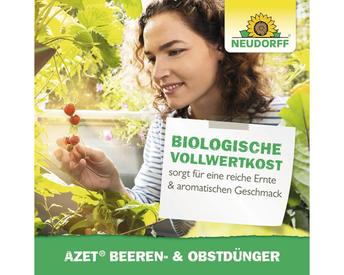 Frau im Garten mit Erdbeeren und Neudorff Logo, die AZET Beeren- und Obstdünger verwendet