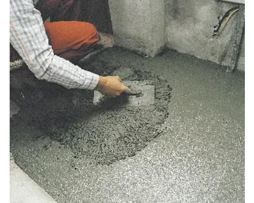 Handwerker glättet Estrich mit einer Glättkelle