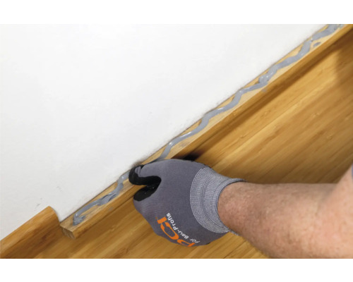 Anbringen von Dichtmasse zwischen Wand und Bodenleiste