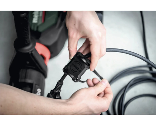 Metabo Logo auf Kabelaufwicklung mit Bohrmaschine im Hintergrund