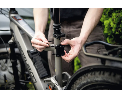 Nahaufnahme eines Mannes, der ein Fahrradzubehör an einem Fahrrad befestigt