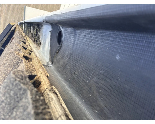 Detailansicht einer Dachrinne mit Bitumenabdichtung und Ablaufrohr