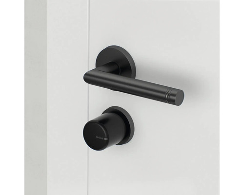 Schwarze Türklinke mit Schloss auf weißer Tür